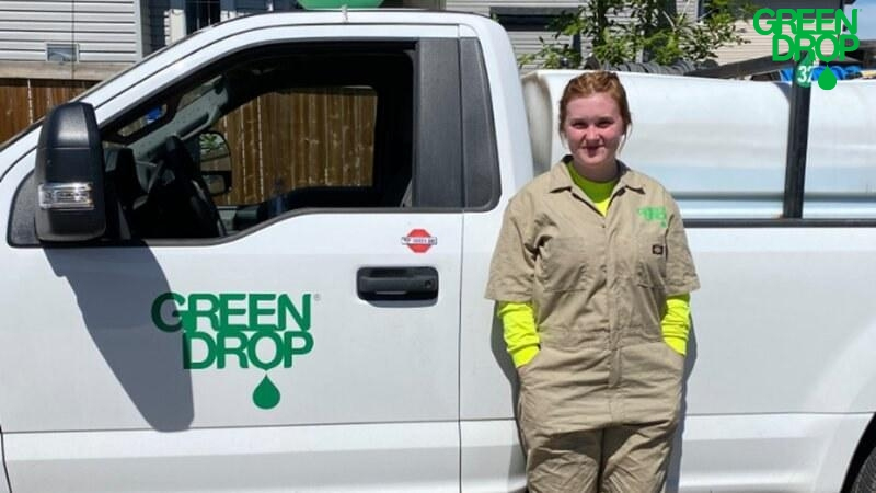 Green Drop employee posing next to a company truck