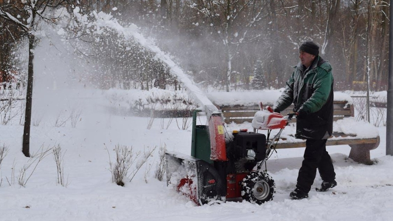 Man clearing snow with a machine