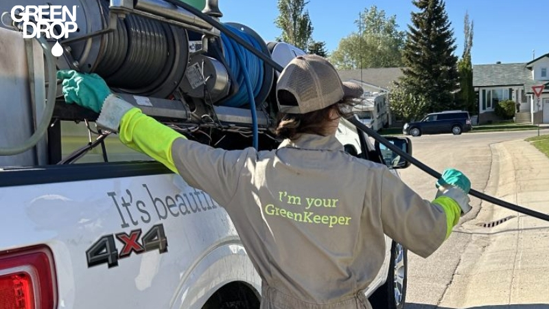 Green Drop worker next to their truck