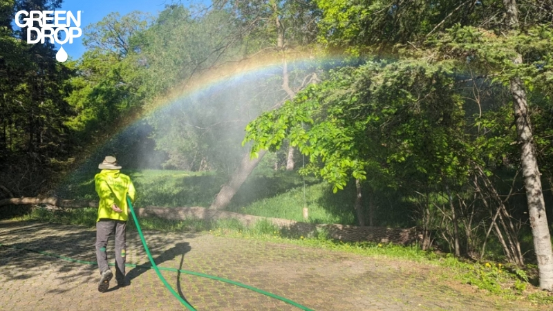 Green Drop worker watering trees in Calgary during restrictions