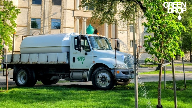 Green Drop water truck watering trees in Calgary