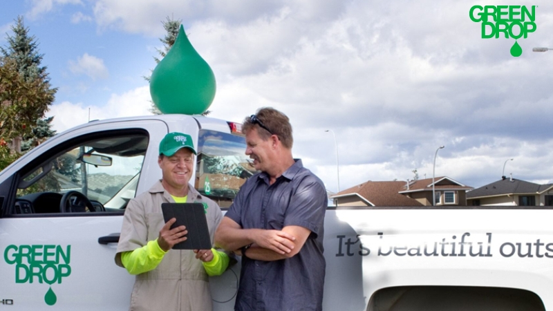 Green Drop employee talking with a customer in front of a truck