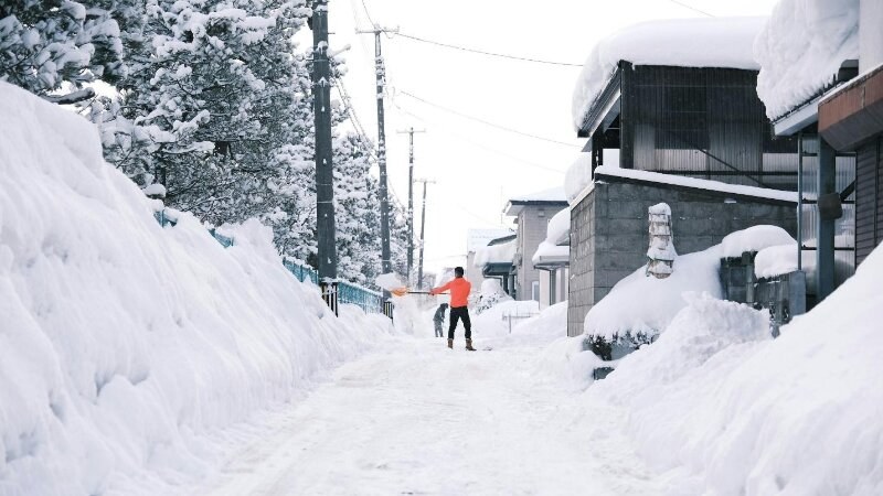 Man shovelling snow in the street